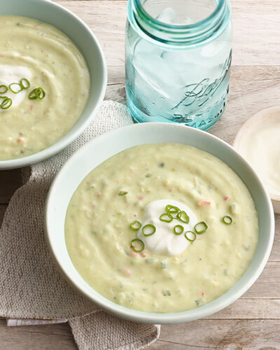 Avocado cucumber soup in a bowl with a dollop of Mountain High yoghurt