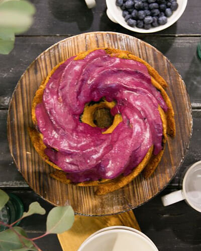 Blueberry yoghurt cake on a table scape with silverware and dishes