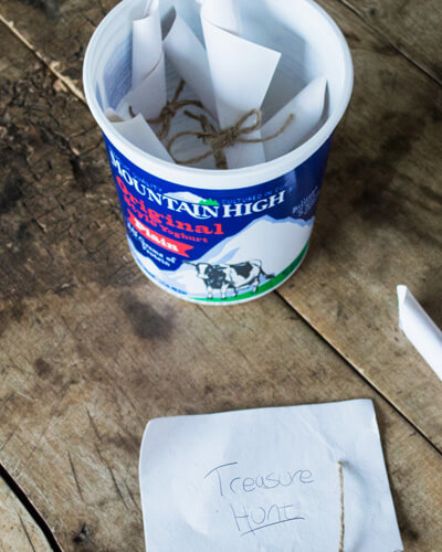 bucket list items written on paper and placed in a yoghurt tub