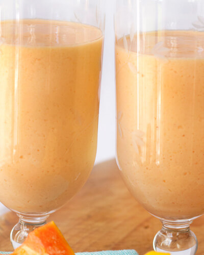 Two glasses filled with papaya mango smoothie