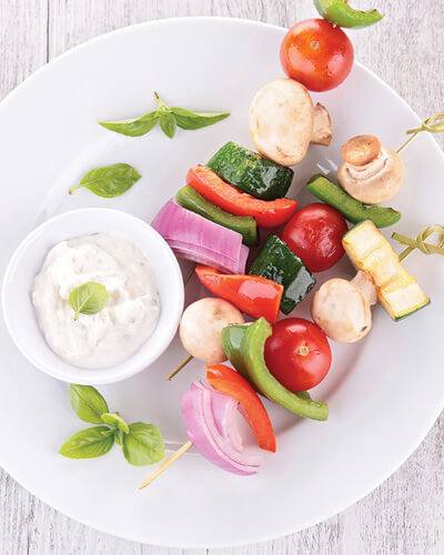 cup of toasted cumin yoghurt dip with vegetable kabobs